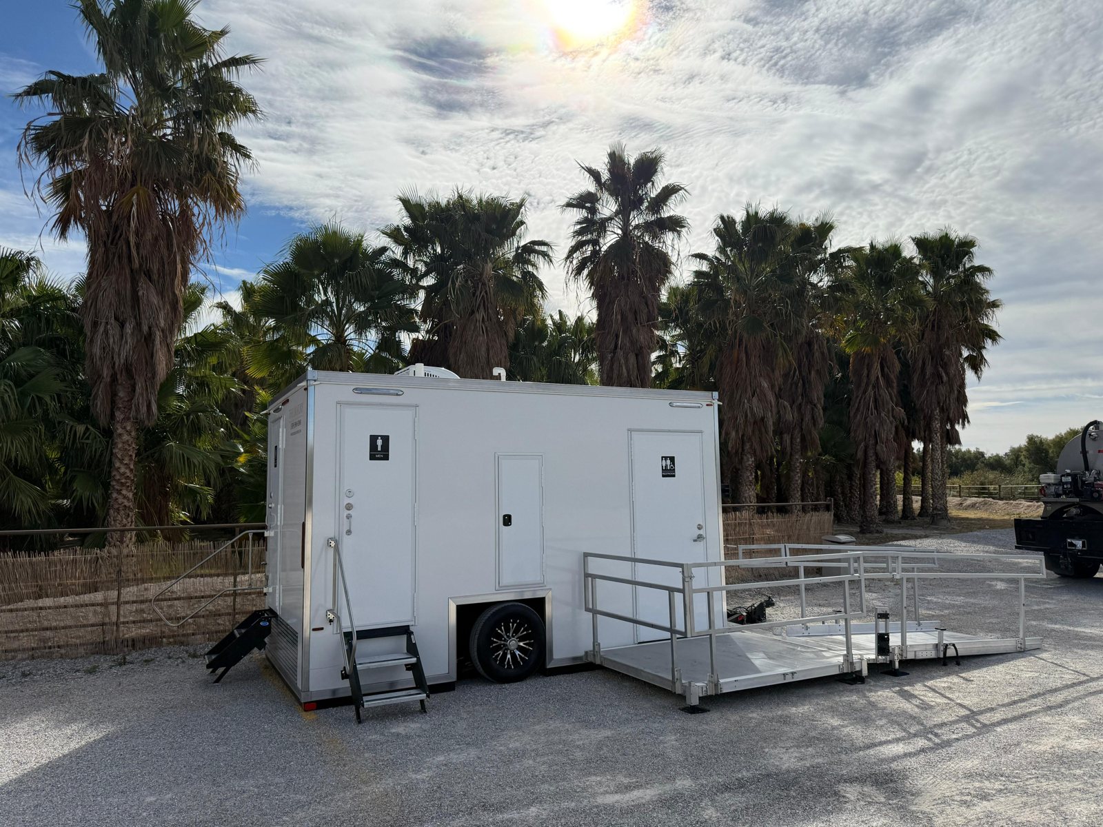 An ADA restroom trailer from The Lavatory with its ramp deployed, set up for a site in West Jordan, Utah
