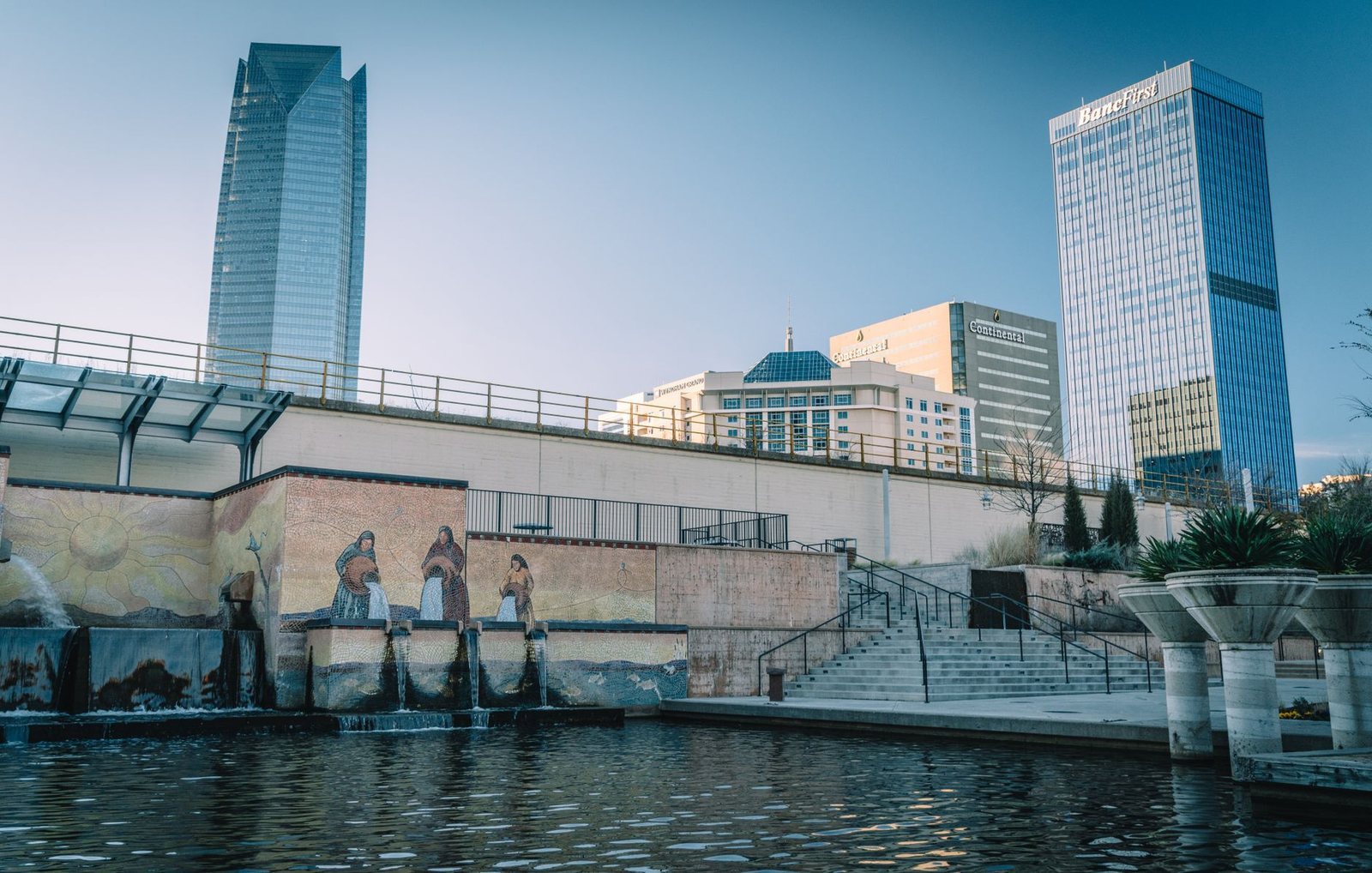 Devon Tower and the BancFirst tower rising over the canal walk and its tile mural in downtown Oklahoma City