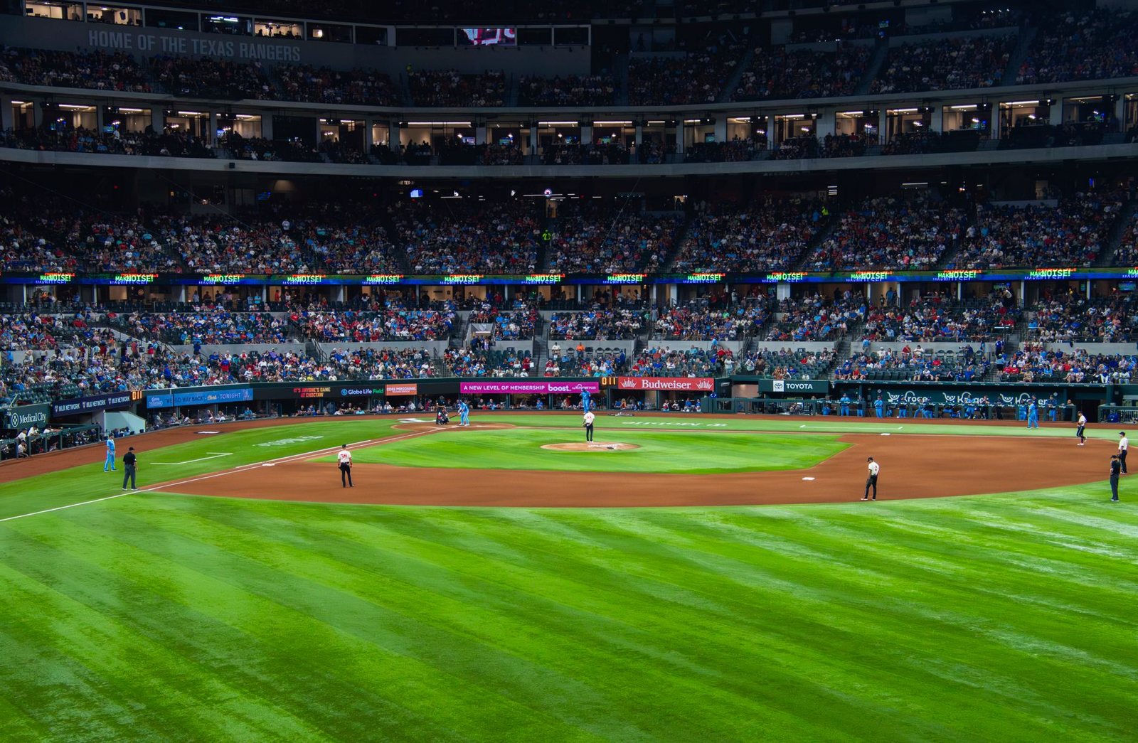 A baseball game under the roof at Globe Life Field in Arlington, Texas, with a full infield and outfield in view
