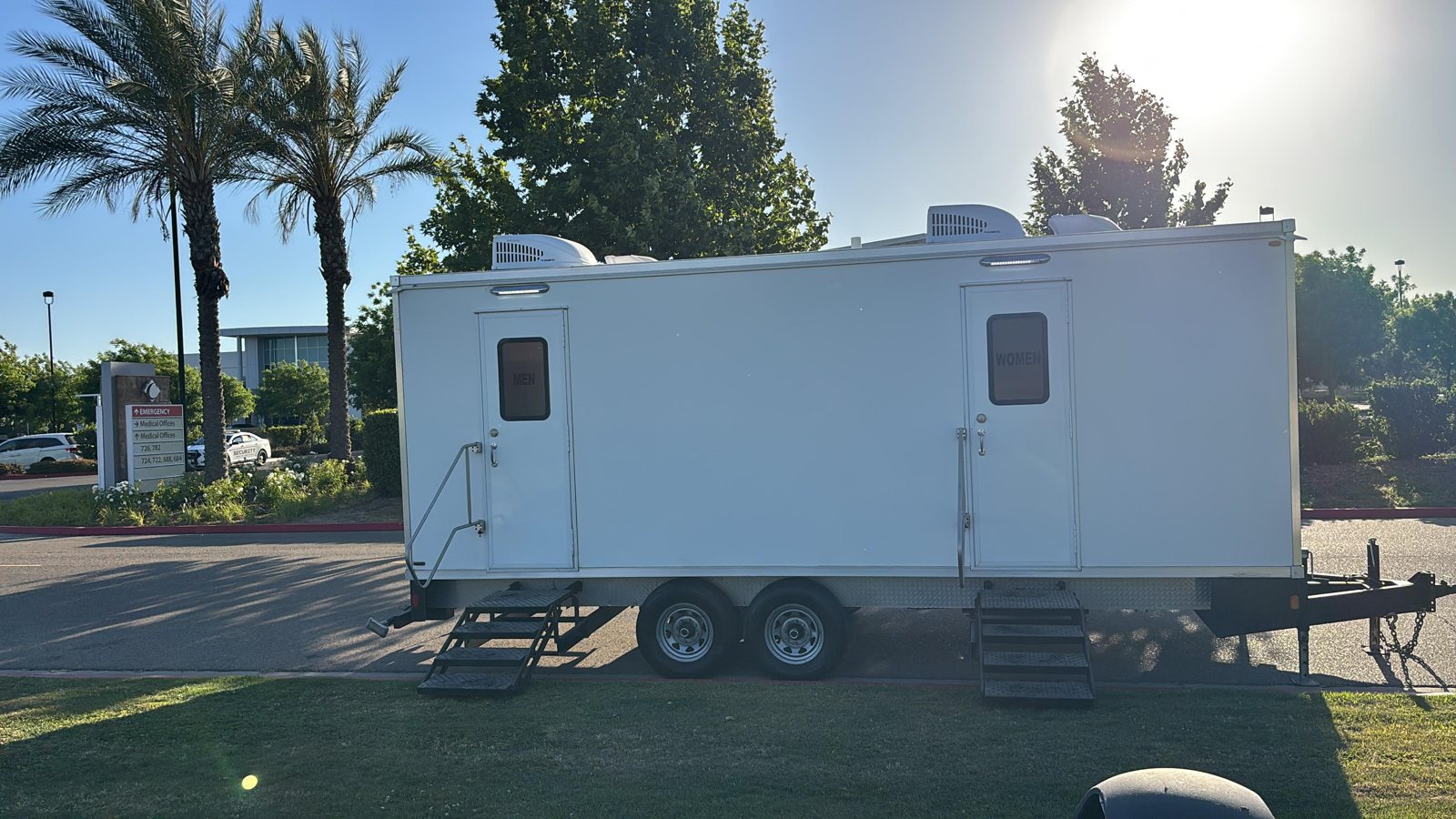 A Lavatory luxury restroom trailer set up for an event in Orem, Utah, with flushing china toilets, running water, and climate control inside
